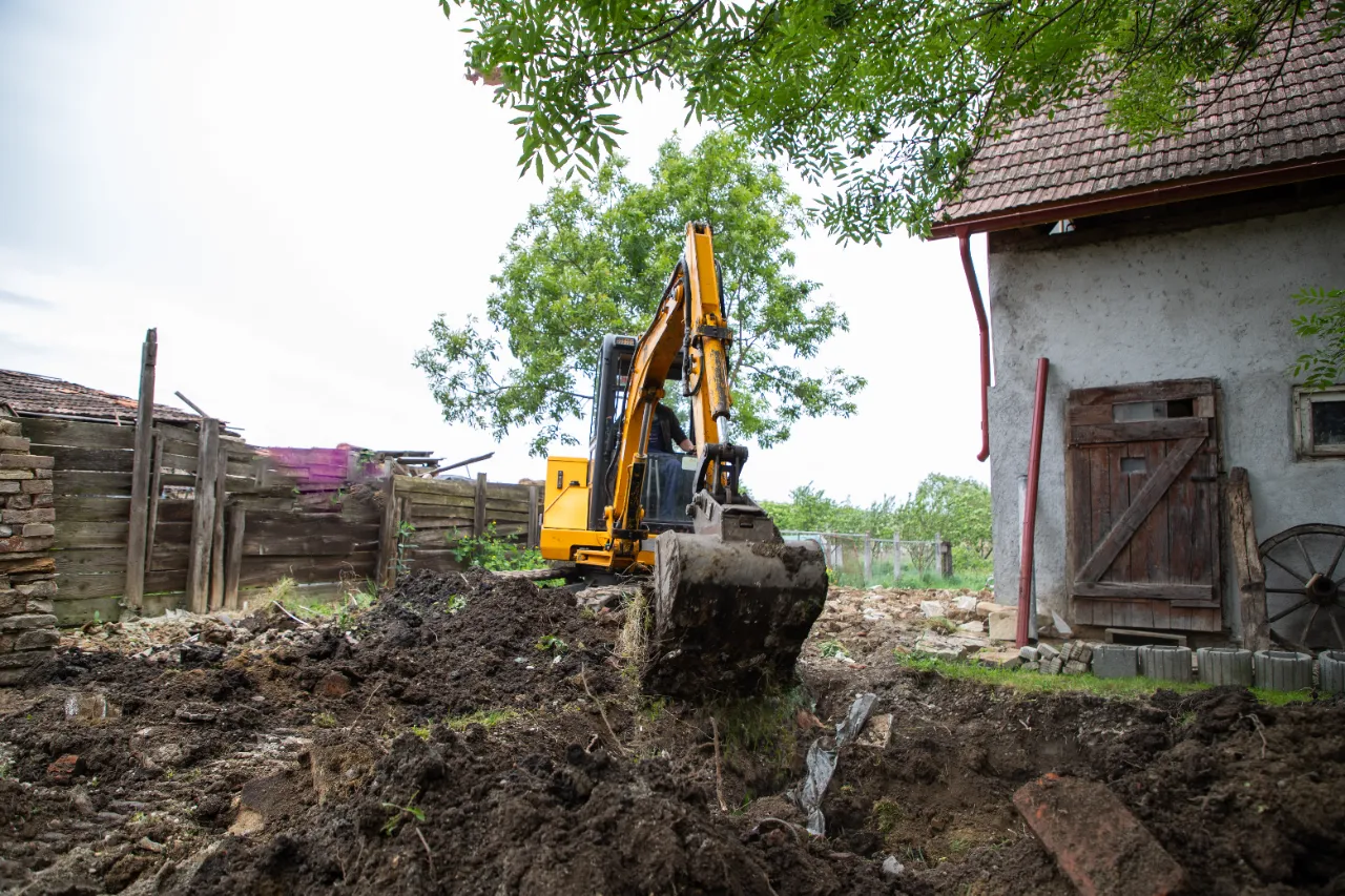 Excavator with bucket lifting soil