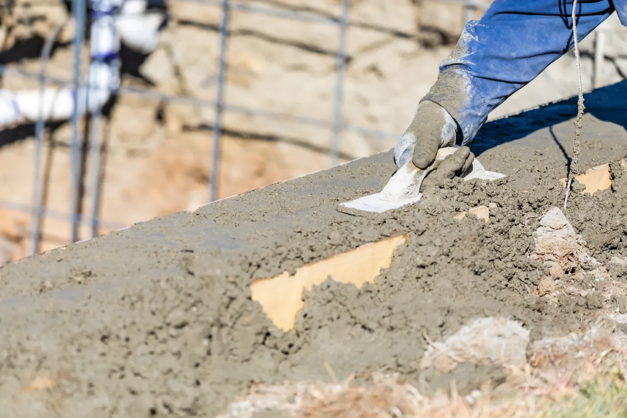 Worker with wood float on concrete